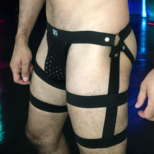 Male model wearing custom-made black elastic strap harness shorts by Cheeky Boy Harness, designed for fetishwear, clubwear, or festival fashion.