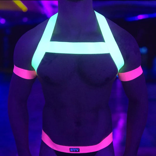 Model wearing a neon yellow chest harness with matching neon pink bicep bands and waistband jockstrap by Cheeky Boy Harness. Customisable colour options available. Perfect for festivals, clubwear, and pride events.