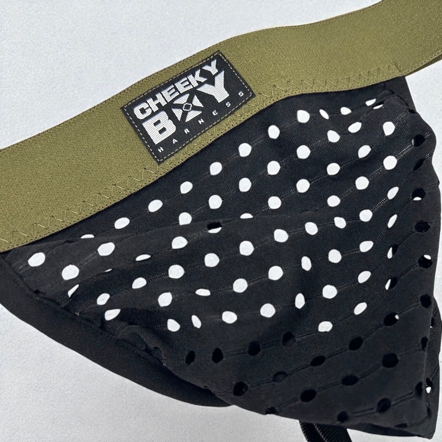 Men’s black mesh jockstrap with army green elastic waistband, featuring a Cheeky Boy Harness brand logo at the centre. Close up shot showing mesh holes clearly. 