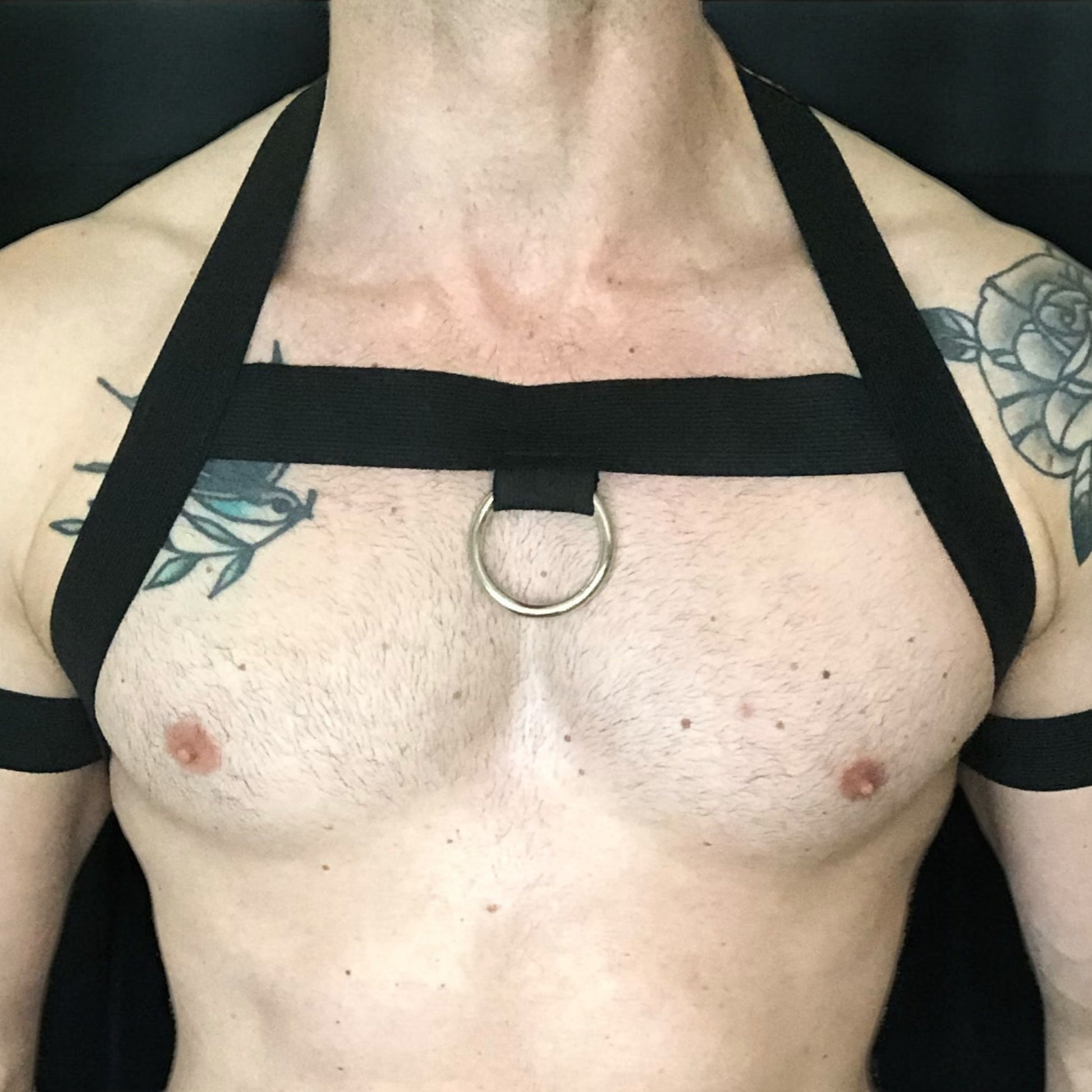 Model wearing a custom-made made elastic chest harness and black mesh jockstrap by Cheeky Boy Harness. Made-to-measure men's festival and clubwear set designed for pride, circuit parties, and dance events