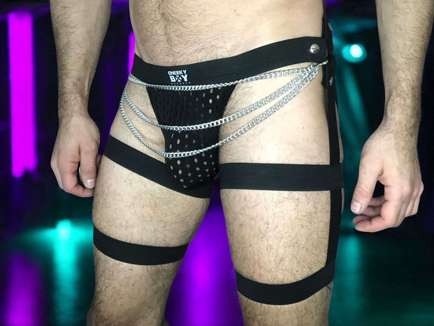 Front view of black thigh strap harness shorts styled over black underwear

