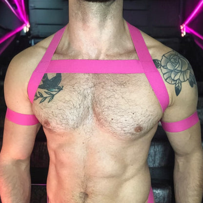 Model wearing a custom-made hot pink elastic chest harness and black mesh jockstrap by Cheeky Boy Harness. Made-to-measure men's festival and clubwear set designed for pride, circuit parties, and dance events