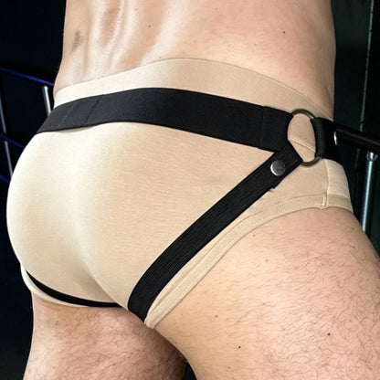 Rear three-quarter view of the standalone Jockstrap with a black waistband and back straps, worn over flesh-coloured underwear for display.