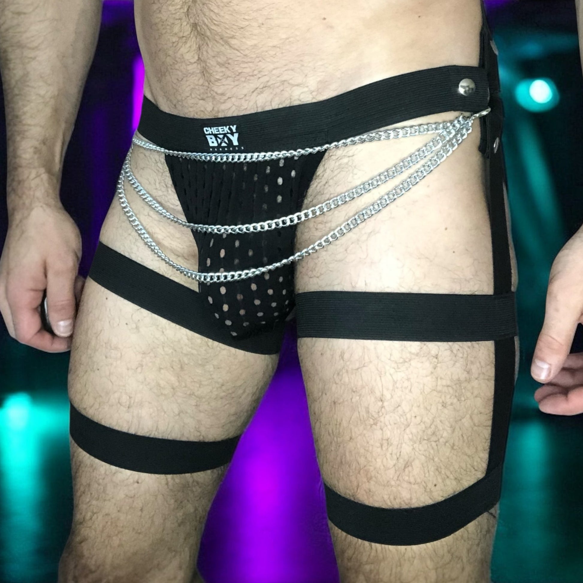 Male model wearing custom-made black elastic strap harness shorts by Cheeky Boy Harness, designed for fetishwear, clubwear, or festival fashion.