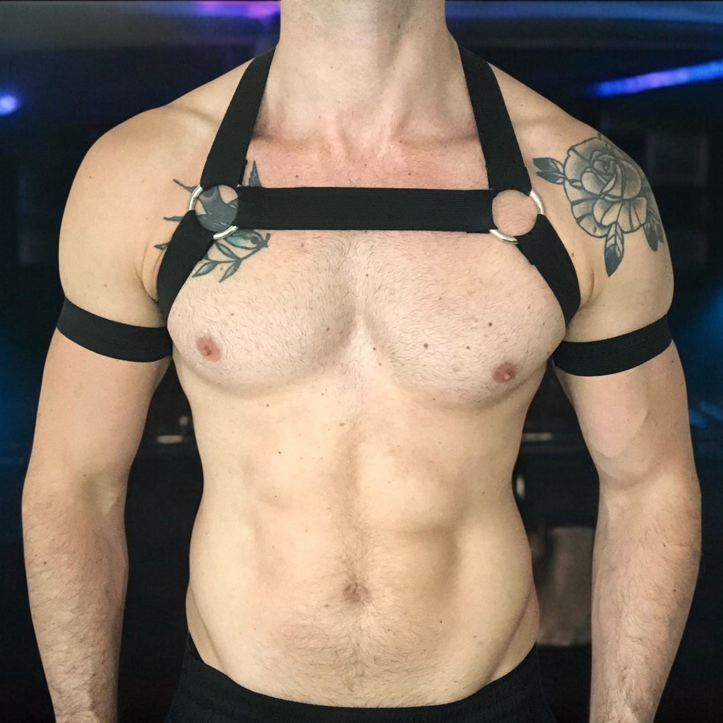 Model wearing a black elastic full body harness with metal rings and matching jockstrap, handmade by Cheeky Boy Harness – custom fit for clubwear, pride, and fetish events