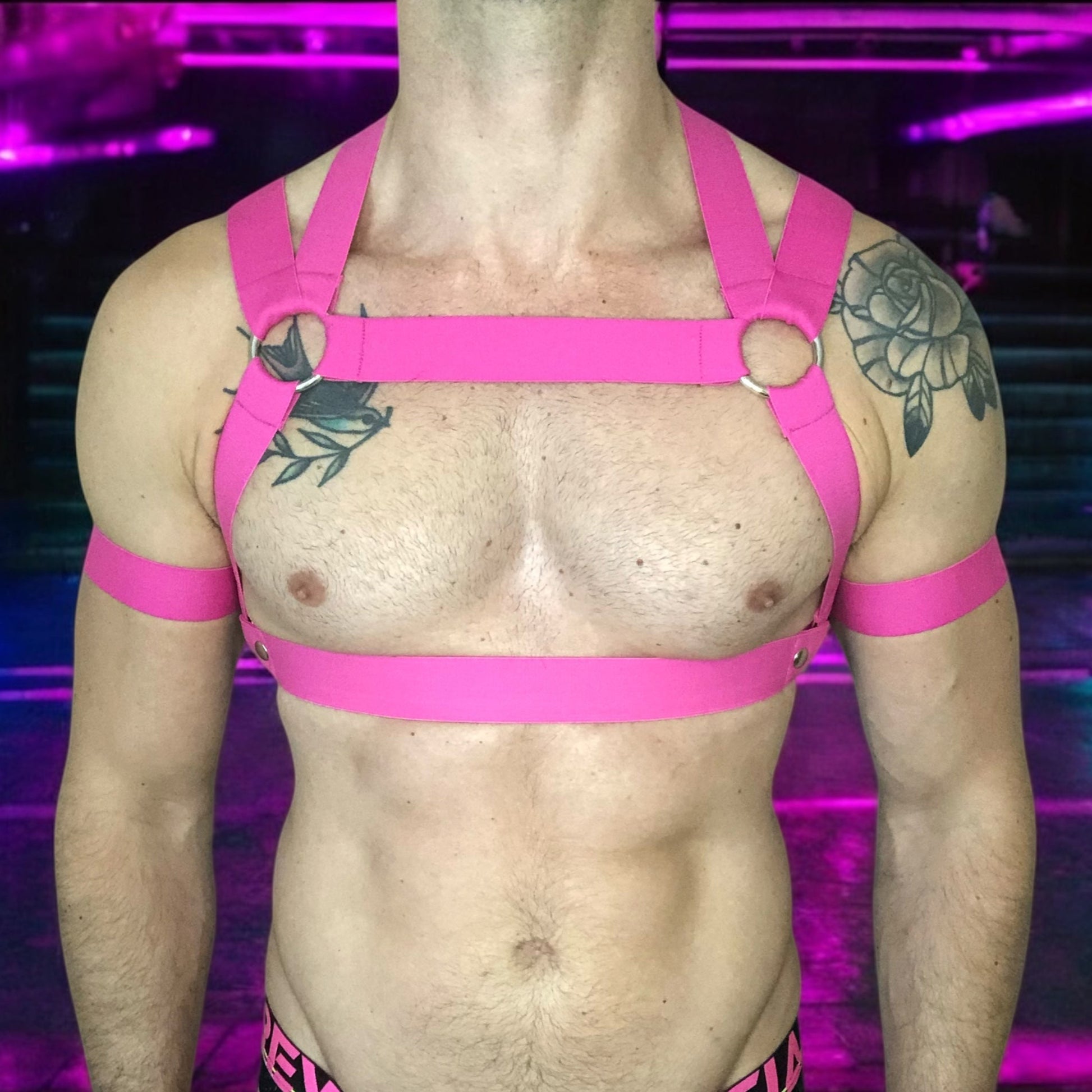 Man Wearing a Made-To-Measure Hot Pink Elastic Body Harness with Metal Rings and Matching Bicep Bands by Cheeky Boy Harness