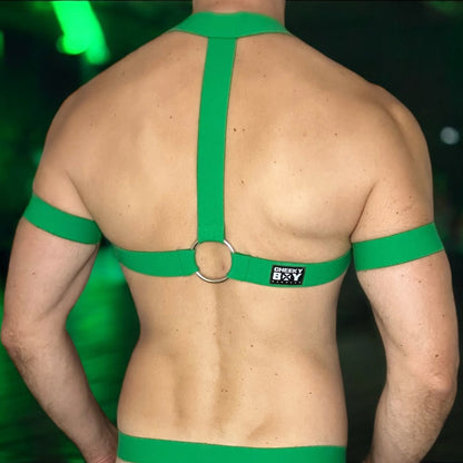 Model wearing a made-to-measure, full body harness in emerald green by Cheeky Boy Harness. The outfit features elasticated chest straps, matching thigh bands, and a black mesh jockstrap with a soft, stretchy pouch. Designed for a bold custom fit, this handmade set is ideal for Pride events, club nights, and fetish wear.