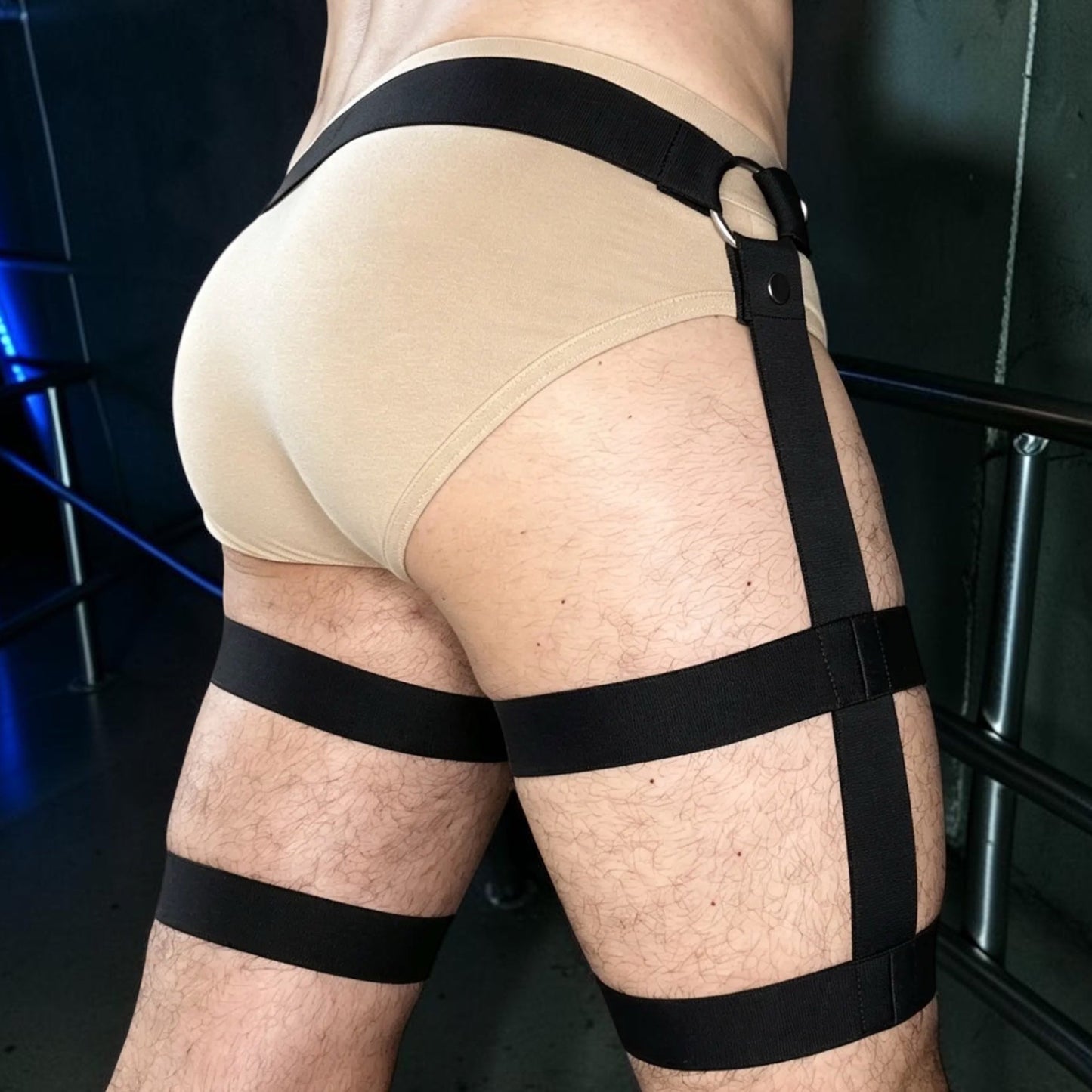 Rear three-quarter close-up of the black waistband and detachable double-banded Leg Loops worn over flesh-coloured underwear.